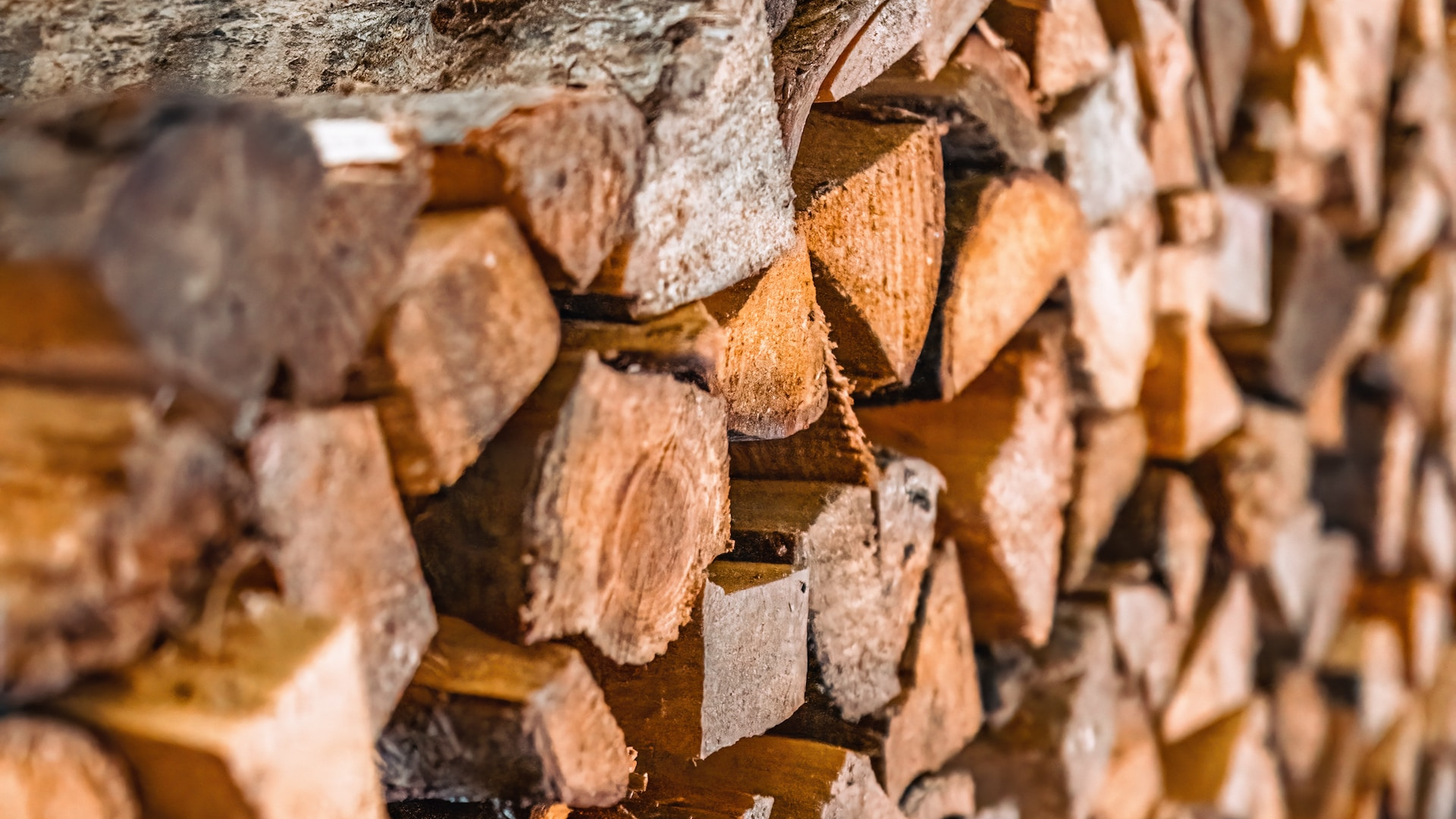 A neat stack of wood logs arranged in a tidy wood pile.