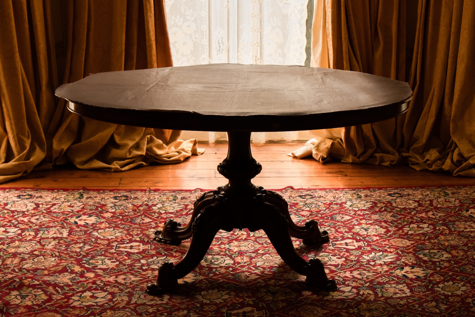 An elegantly crafted wooden table placed near a window. It forms a picturesque setting for productive work or focused study.